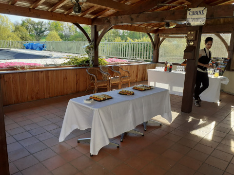 Overdekt buitenterras bij Domaine Papillon, Occitanië, Frankrijk met snacks, dranktafels en een serveerster.