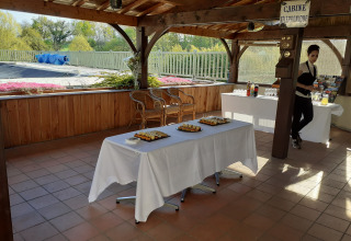 Overdekt buitenterras bij Domaine Papillon, Occitanië, Frankrijk met snacks, dranktafels en een serveerster.