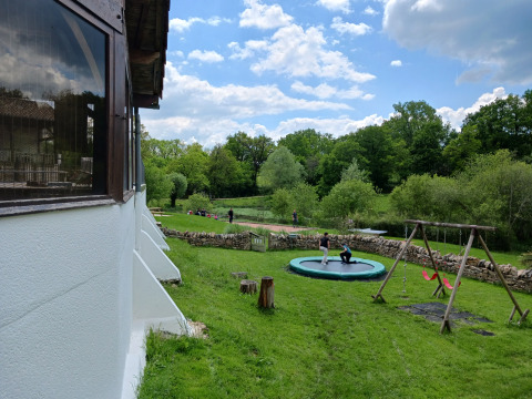 Uitzicht op Domaine Papillon in Occitanië, Frankrijk, met kinderen op trampoline en schommels buiten.