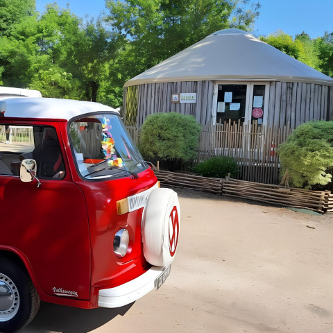 Furgone Volkswagen rosso parcheggiato davanti a una capanna al Camping «les Rives de Grand Lieu» in Pays de la Loire.