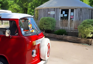 Furgone Volkswagen rosso parcheggiato davanti a una capanna al Camping «les Rives de Grand Lieu» in Pays de la Loire.