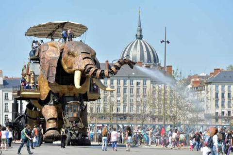 Elefante meccanico gigante spruzza acqua sulle persone al Camping les Rives de Grand Lieu, Pays de la Loire.