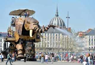 Elefante meccanico gigante spruzza acqua sulle persone al Camping les Rives de Grand Lieu, Pays de la Loire.