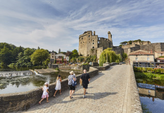 Famiglia che passeggia su un ponte di pietra vicino a un castello sul fiume a Saint-Philbert-de-Grand-Lieu, Pays de la Loire.
