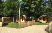 Foto delle tende safari Coco Sweet al Camping les Rives de Grand Lieu in Francia, circondate da alberi verdi.