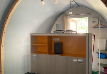 Interno di una tenda safari Coco Sweet al Camping les Rives de Grand Lieu in Francia, con letto e mensole.