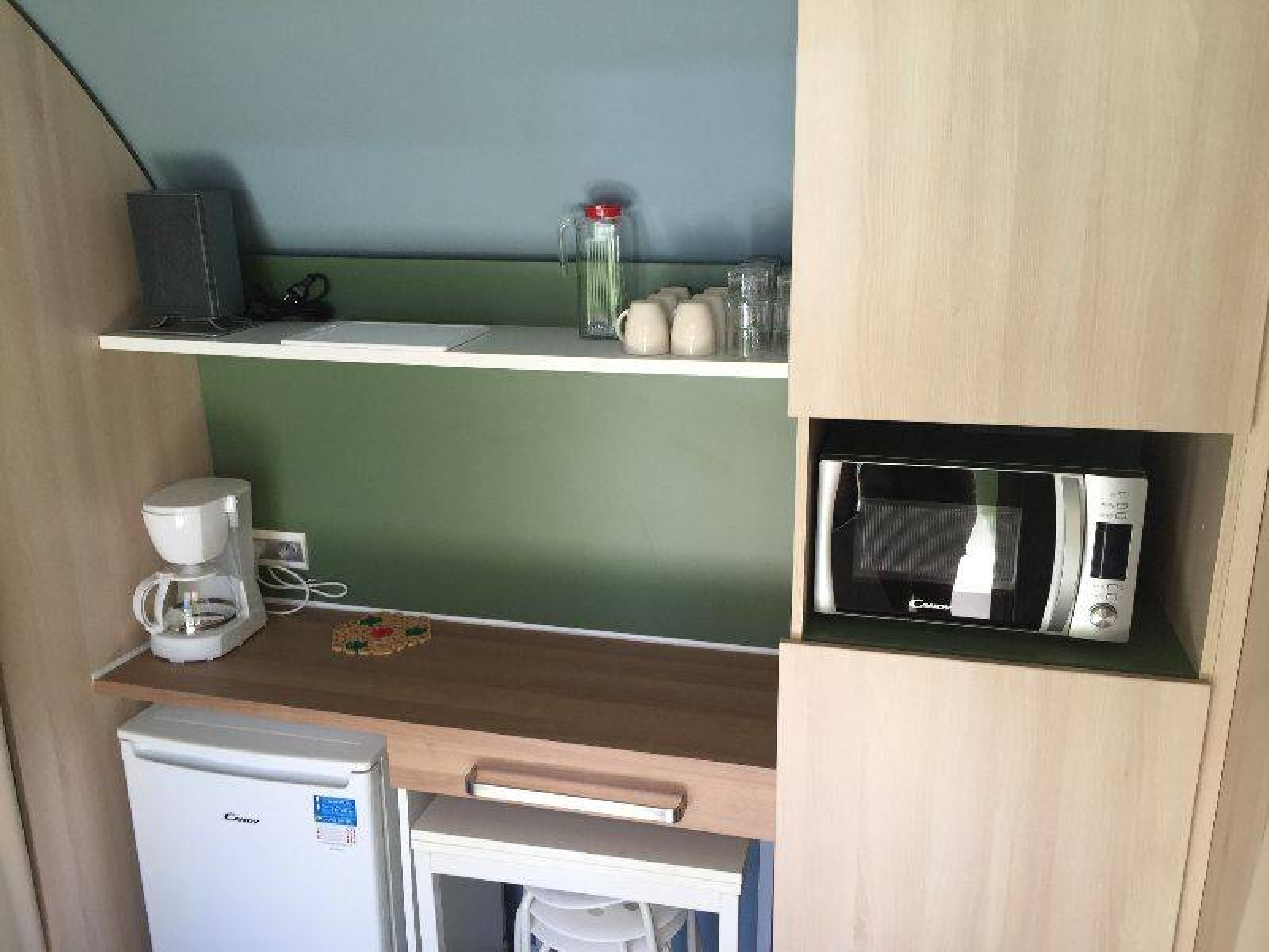 Een compacte kitchenette in een Coco Sweet safaritent op Camping les Rives de Grand Lieu in Frankrijk, met koffiezetapparaat, magnetron en minikoelkast.
