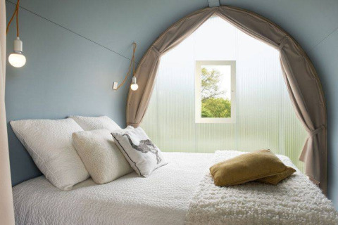 Interno di una tenda safari Coco Sweet con letto accogliente al Camping les Rives de Grand Lieu in Francia.