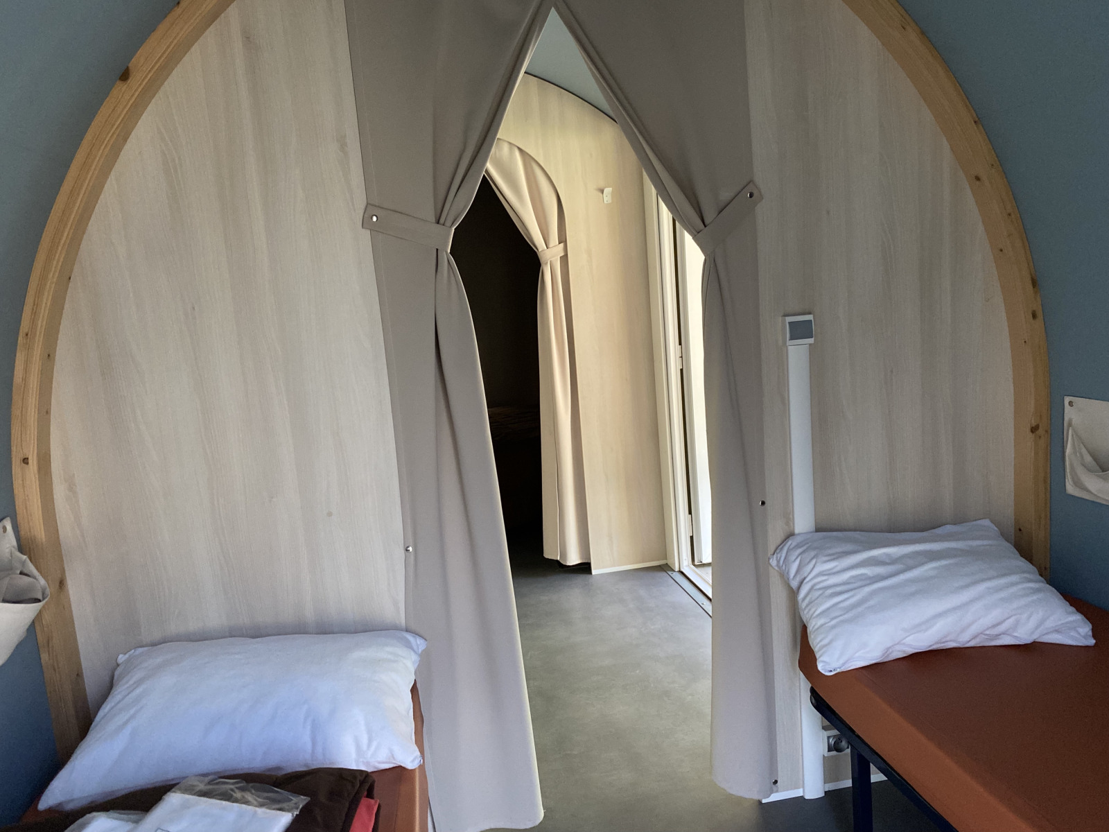Interieur van een Coco Sweet safaritent met twee bedden en gordijnen op Camping les Rives de Grand Lieu in Frankrijk.