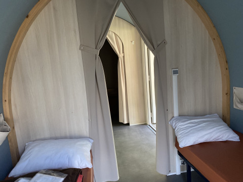 Vista interna di una tenda safari Coco Sweet con due letti e tende al Camping les Rives de Grand Lieu in Francia.