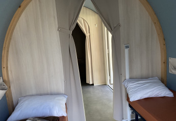 Vista interna di una tenda safari Coco Sweet con due letti e tende al Camping les Rives de Grand Lieu in Francia.
