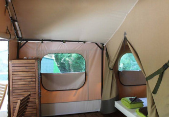 Interno della tenda safari Kenya Lodge con mobili in legno al Camping les Rives de Grand Lieu, Francia.