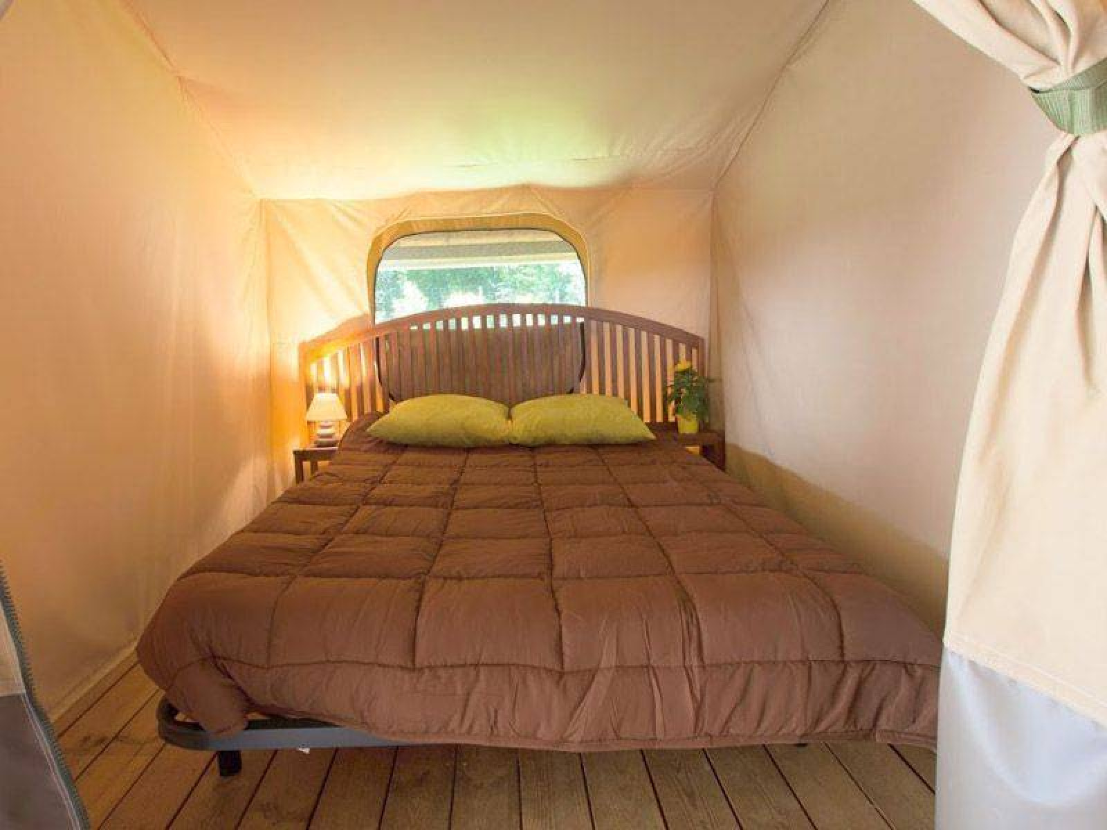 Interieurfoto van een comfortabel bed in de Kenya Lodge safaritent op Camping les Rives de Grand Lieu, Frankrijk.