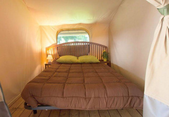 Vista interna di un comodo letto nella tenda safari Kenya Lodge al Camping les Rives de Grand Lieu, Francia.