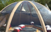 Casa natura Transparent Bell al Camping les Rives de Grand Lieu, con cuscini all’interno di una cupola trasparente.