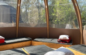 Interno della Transparent Bell al Camping les Rives de Grand Lieu, Francia, con letti e cuscini esposti.