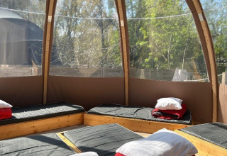 Interno della Transparent Bell al Camping les Rives de Grand Lieu, Francia, con letti e cuscini esposti.