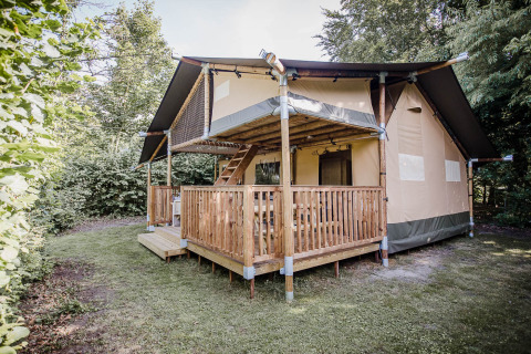 Safaritent Ranger Lodge op Baalse Hei in België, omgeven door groen en een houten terras.
