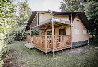 Safaritent Ranger Lodge op Baalse Hei in België, omgeven door groen en een houten terras.