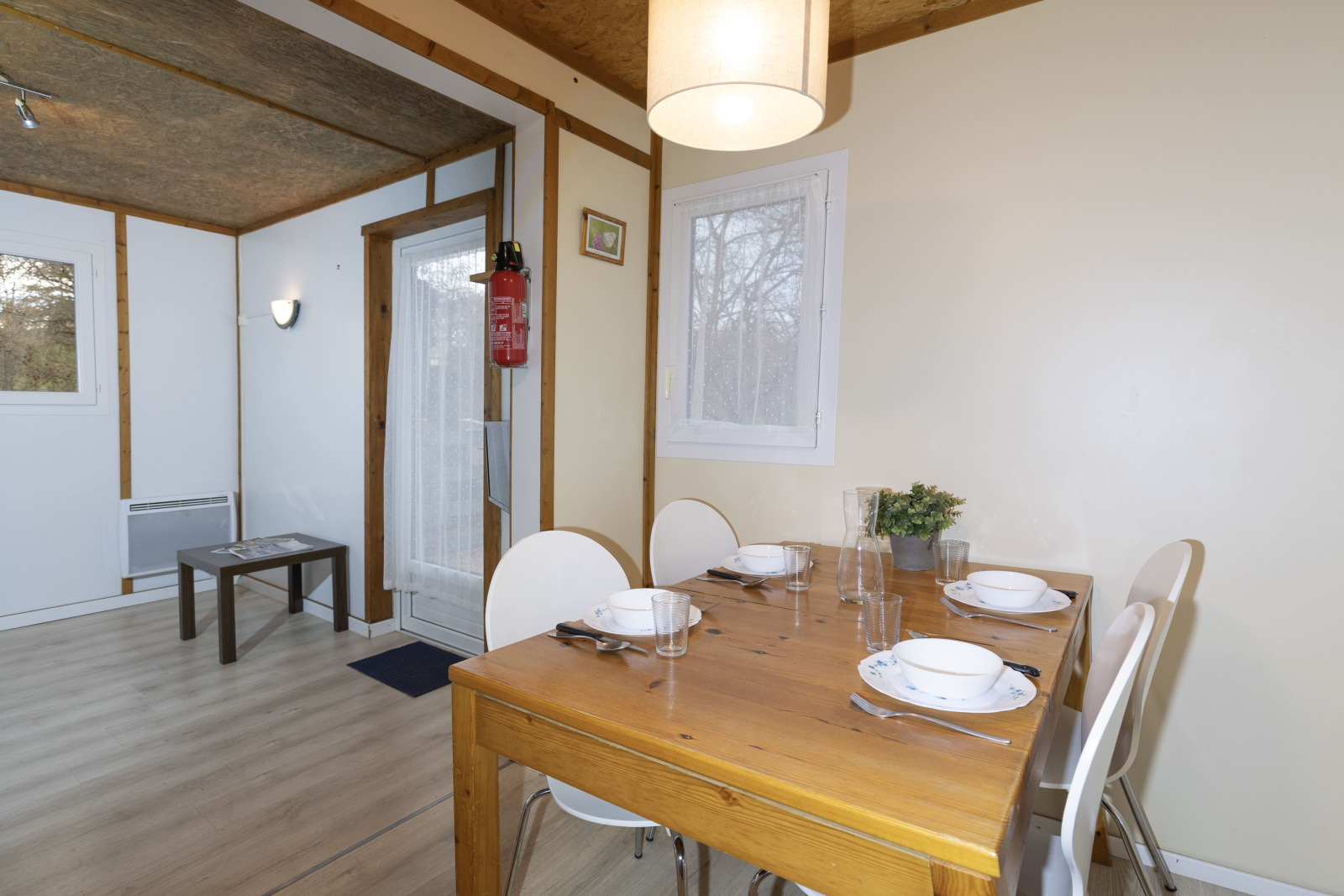 Eetruimte van Cottage Aporia bij Domaine Papillon in Frankrijk, met houten tafel gedekt voor vier personen.