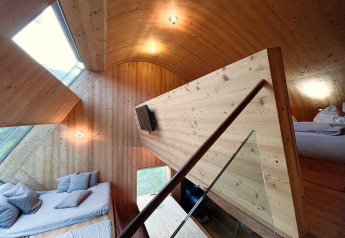 Modernes Holzinterieur im Ufogel-Naturhaus in Österreich mit gemütlichem Ambiente und großen Fenstern.