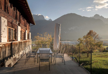 Terrasse des Ufogel Naturhauses in Österreich mit herrlichem Bergblick bei Sonnenuntergang.