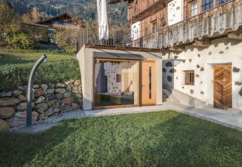 Moderne Anbau mit Glasfront an traditionellem Haus im Gebirge, Naturhaus Ufogel in Österreich.