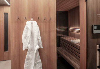 Moderne Sauna mit Holzwänden, Bademantel und Handtuch im Ufogel Nature House in Österreich.
