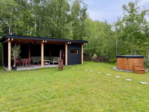 Area esterna della Forest villa «De Bosburcht» con terrazza coperta e hot tub nei Paesi Bassi.