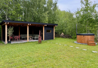 Buitenruimte bij Forest villa «De Bosburcht» met overdekt terras en ronde hottub in Nederland.