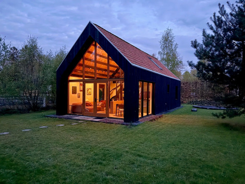 Avondfoto van Forest villa «De Bosburcht» bij De Kremmer in Nederland, warm verlicht en omgeven door bomen.