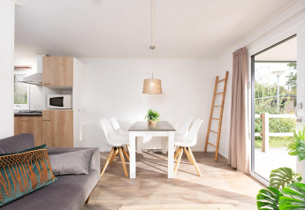 Intérieur lumineux avec salle à manger, cuisine et canapé au Holiday park Mölke, Pays-Bas.