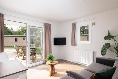 Salon lumineux au Bungalette comfort avec véranda au Holiday park Mölke, Pays-Bas, vue sur terrasse.