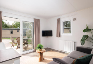 Salon lumineux au Bungalette comfort avec véranda au Holiday park Mölke, Pays-Bas, vue sur terrasse.