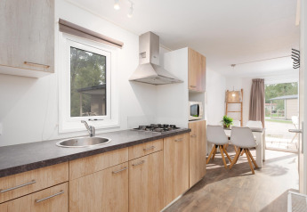 Cuisine moderne et coin repas dans Bungalette Comfort avec véranda au Holiday Park Mölke, Pays-Bas.