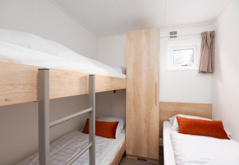 Chambre avec lits superposés, lit simple et armoire en bois au parc Holiday park Mölke, Pays-Bas.