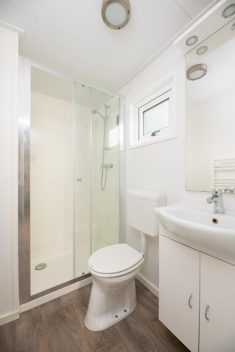 Modernes Badezimmer mit Dusche, WC und Waschbecken in der Bungalette Comfort im Holiday Park Mölke.