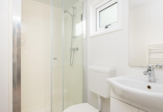 Modernes Badezimmer mit Dusche, WC und Waschbecken in der Bungalette Comfort im Holiday Park Mölke.