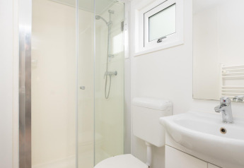 Salle de bain moderne avec douche, toilettes et lavabo dans le Bungalette Comfort au Holiday park Mölke.
