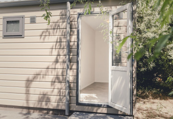 Entrée d’un lodge moderne avec porte ouverte et petite fenêtre au Holiday park Mölke, Pays-Bas.