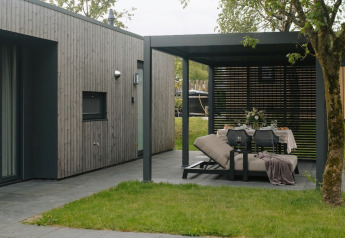 Modern outdoor lounge and dining area at Oak Lodge, Holiday park Hölte in the Netherlands, stylishly set.