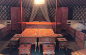Interno di una yurta tradizionale mongola con arredi colorati al Camping Paradis Family des Issoux in Francia.