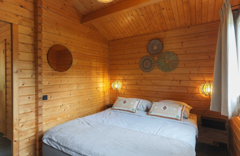 Slaapkamer in houten lodge bij Swedish Village House, Camping De Kleine Wereld in Nederland.