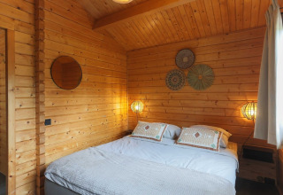 Slaapkamer in houten lodge bij Swedish Village House, Camping De Kleine Wereld in Nederland.