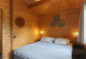 Cozy wooden lodge bedroom at Swedish Village House, Camping De Kleine Wereld in the Netherlands.