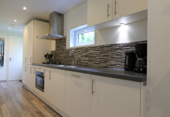 Moderne keuken in Pavilion 6 bij De Achterhoek, Nederland, met witte kasten en een strakke uitstraling.