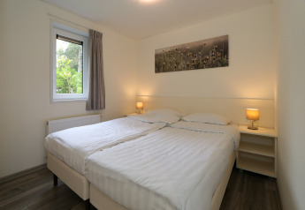 Slaapkamer in Pavilion 6 bij De Achterhoek, Nederland, met twee eenpersoonsbedden en warme verlichting.