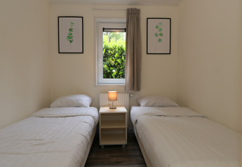 Kamer met twee eenpersoonsbedden, nachtkastje en lamp in Pavilion 6, De Achterhoek, Nederland, modern.