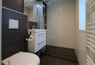 Salle de bains moderne du lodge Pavilion 6 à De Achterhoek, Pays-Bas, avec douche, toilette et lavabo.