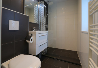 Modern badkamerinterieur in lodge Pavilion 6 op De Achterhoek, Nederland, met douche, toilet en wastafel.